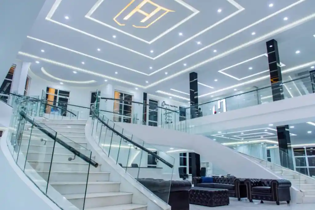 Luxurious modern interior with curved staircase and glass railings, symbolizing Ham Group’s growth.